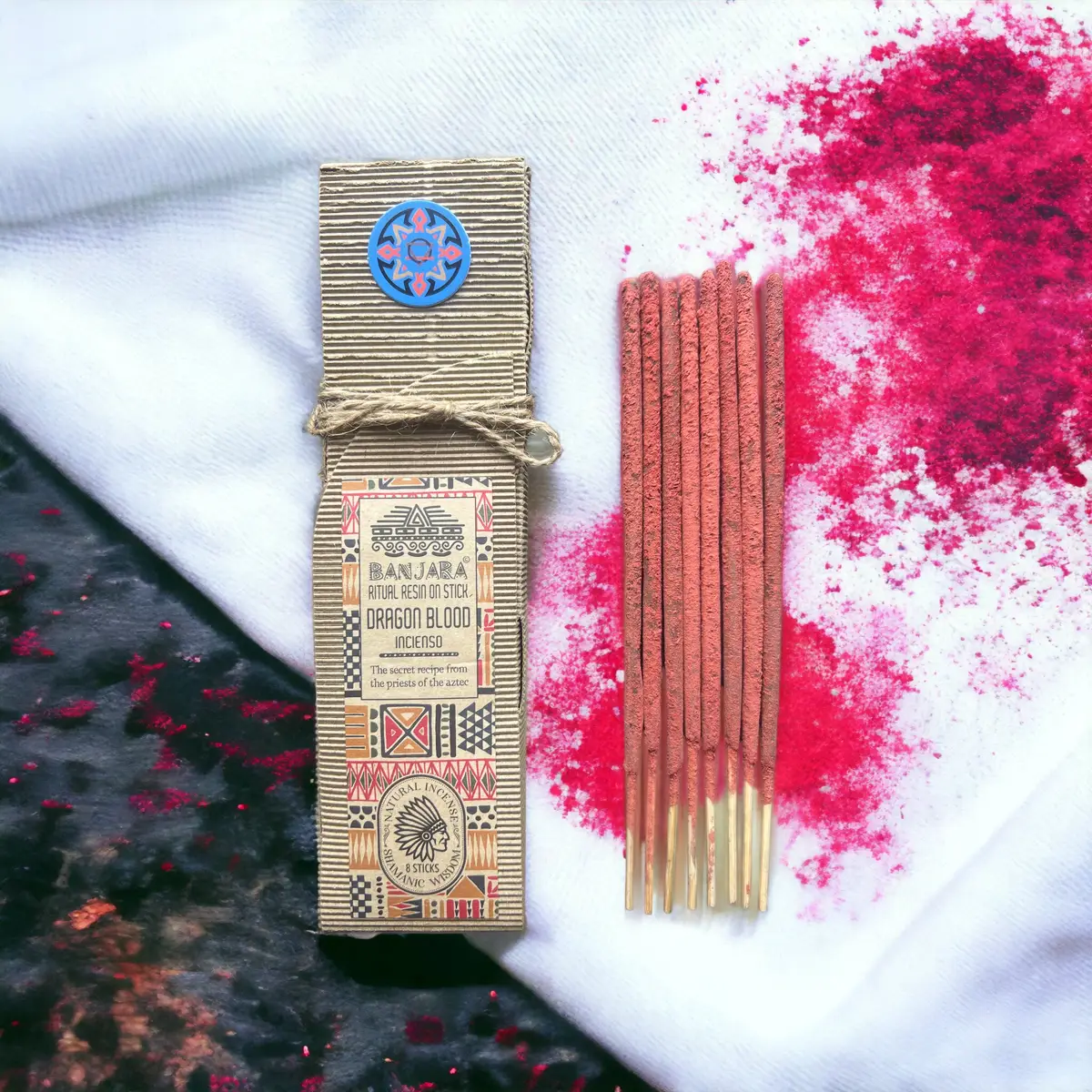 Förpackning med ritualhartser på pinne Dragon Blood och röda rökelsestickor på vit bakgrund