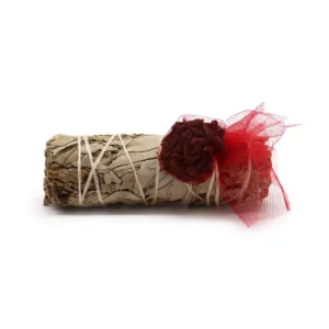 Rökelsesticka med vit salvia och kryddnejlika insvept i rött nät på vit bakgrund