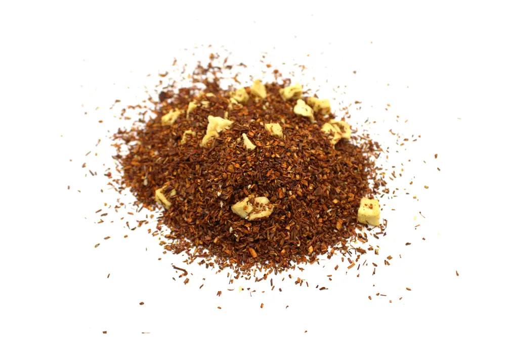 Löst rooibos te med bitar av äpple och kanel på vit bakgrund