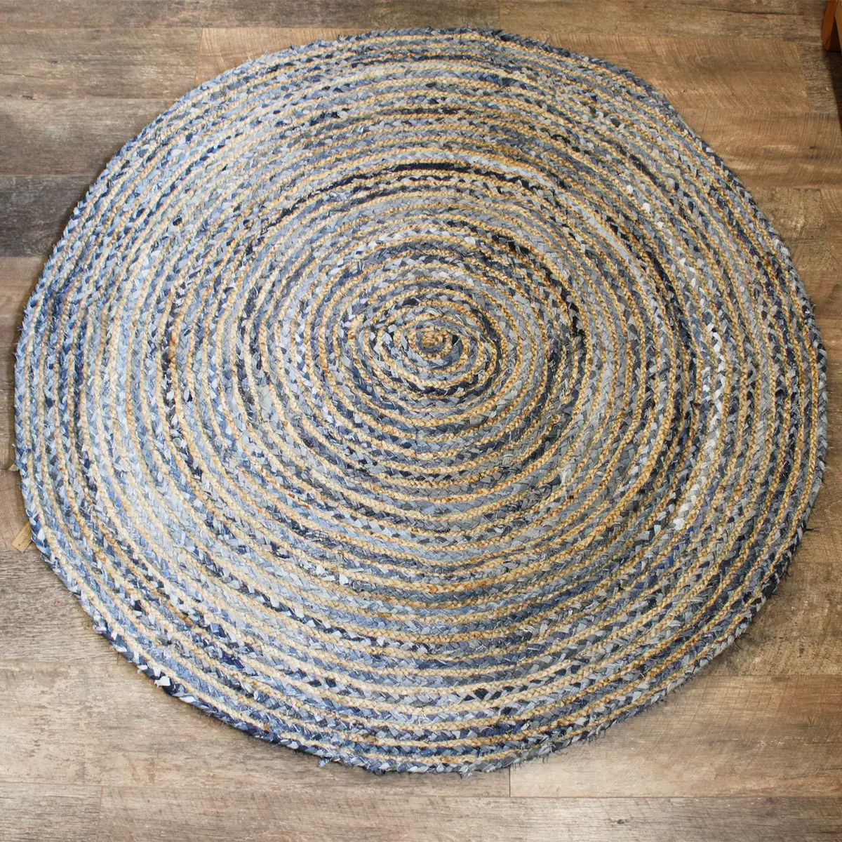 Rund handgjord matta i jute och återvunnen denim på trägolv