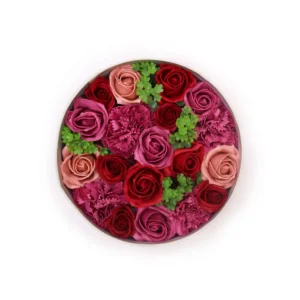 Rund presentask fylld med rosa, röda och lila tvåltrosor och gröna blad