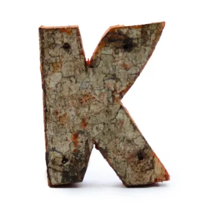 Rustik bokstav K tillverkad av naturlig bark med textur och färgvariationer