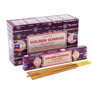 Förpackning med Satya rökelsepinnar Golden Sunrise och lösa rökelsepinnar framför