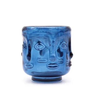 Kungligt blå glasljusstake med stiliserade Buddhaansikten