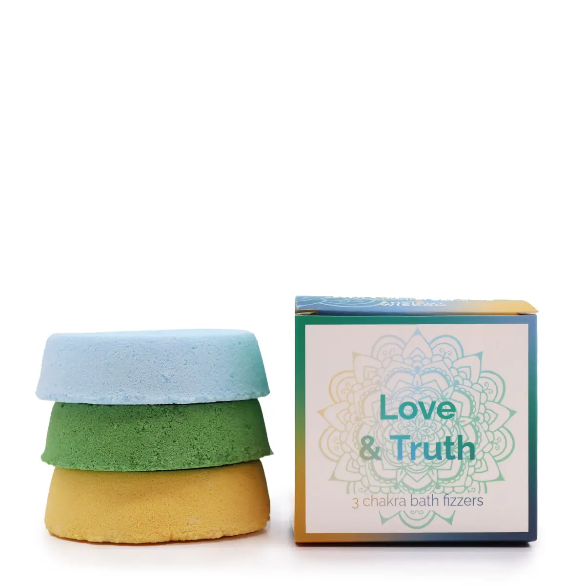 Tre små badbomber i blått, grönt och gult bredvid en presentförpackning med texten Love & Truth