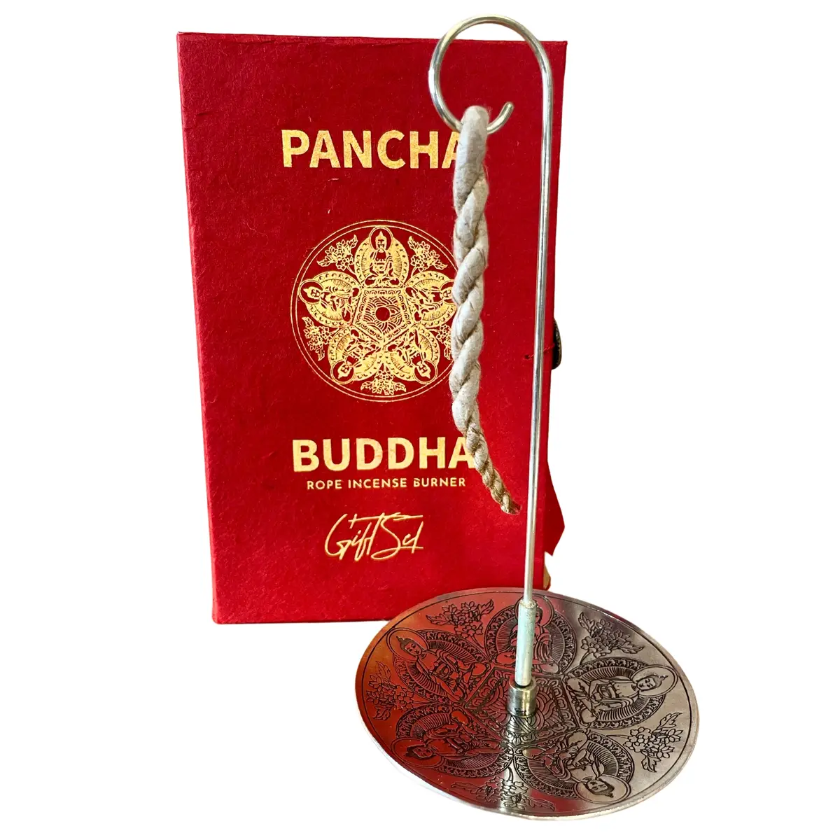 Set med reprökelse och silverpläterad hållare framför röd dekorativ ask med Pancha Buddha-motiv