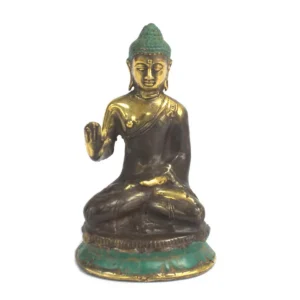 Sittande Buddha-figur i mässing med hand upp på vit bakgrund