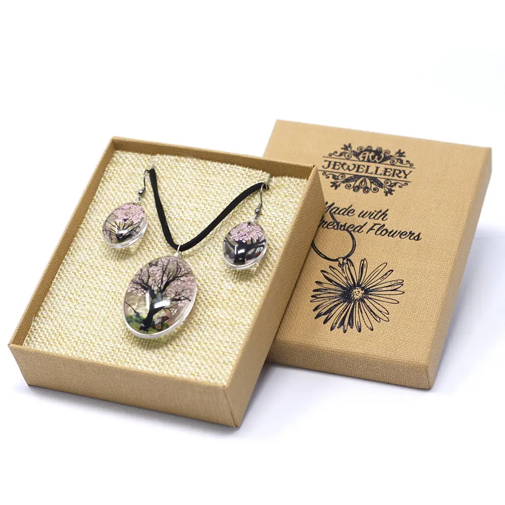 Smyckeset med halsband och örhängen med pressade rosa blommor och livets träd motiv i glas i presentförpackning