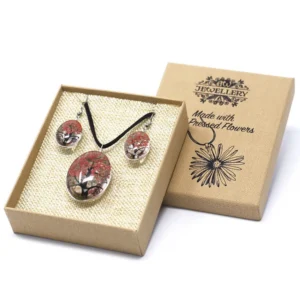 Smyckeset med halsband och örhängen med pressade korallfärgade blommor i glas i presentask