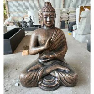 Stor antikgul buddha-staty i meditationsställning i verkstadsmiljö