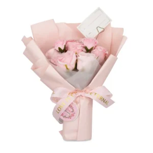 Stor bukett med rosa tvålrosor inslagen i ljusrosa papper med sidenband och presentkort