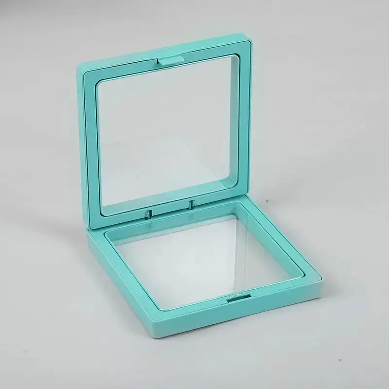 Stor flytande smyckesram i teal färg med transparent fönster, öppen och placerad på ljus bakgrund