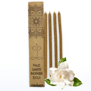 Fyra stora rökelsestickor av Palo Santo bredvid ett dekorativt kraftkuvert och en vit gardenia blomma
