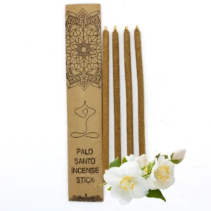 Fyra stora rökelsestickor av Palo Santo bredvid ett dekorativt kraftkuvert och jasminblommor