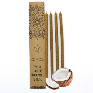 Fyra stora rökelsestickor av Palo Santo bredvid en förpackning och kokosnöt