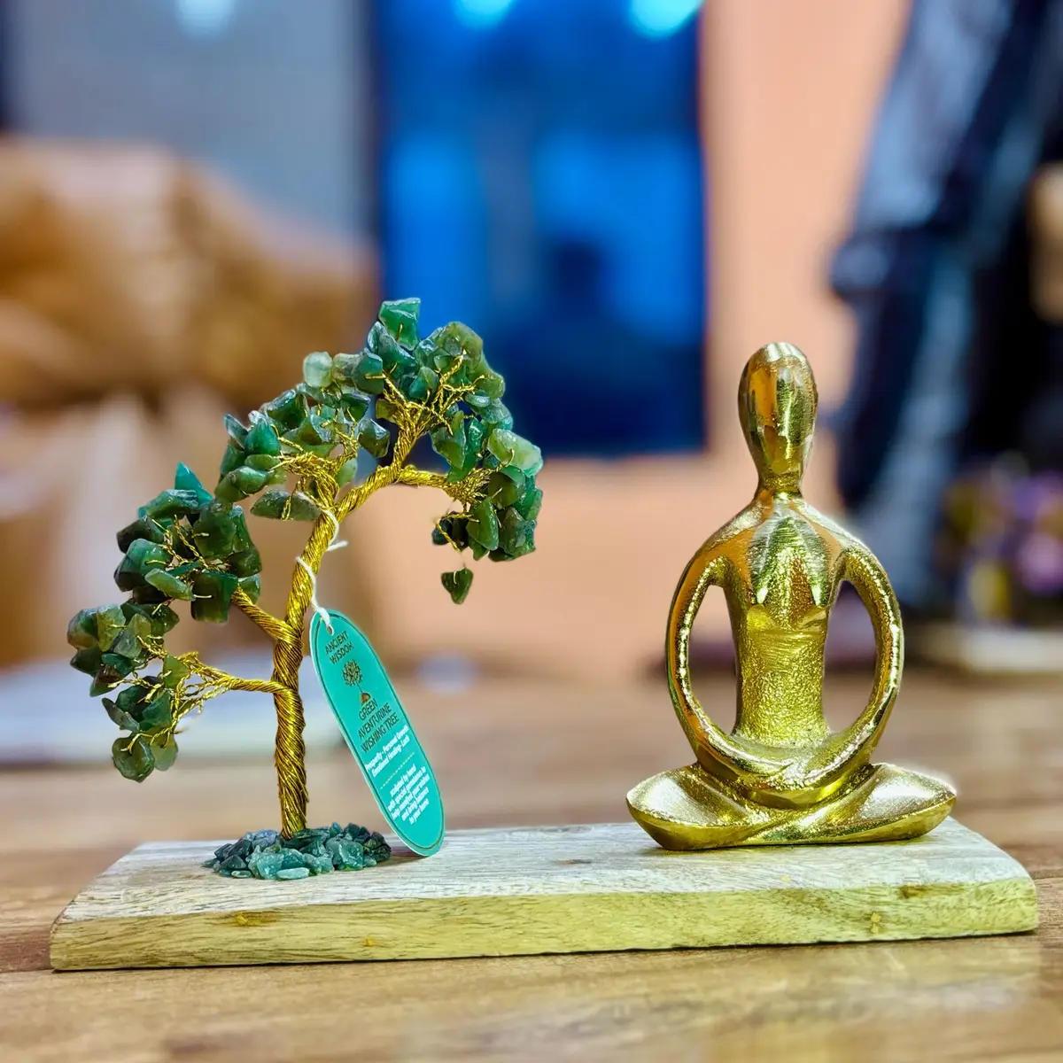 Handgjort träd av grön aventurin med gyllene yogafigur i lotusställning på träplatta