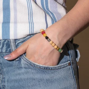 Hand med Tri Hita Karana-armband Love i trä och färgade pärlor