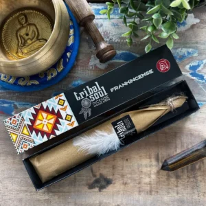 Dekorativ ask med Tribal Soul rökelsestickor och vit fjäder på träbord