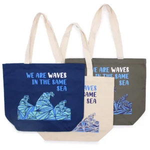 Blå tryckt bomullskasse med texten We are Waves och grafiskt mönster