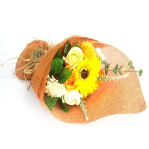 Orange tvålbukett med stående tvålblommor och gröna blad insvept i orange tyg