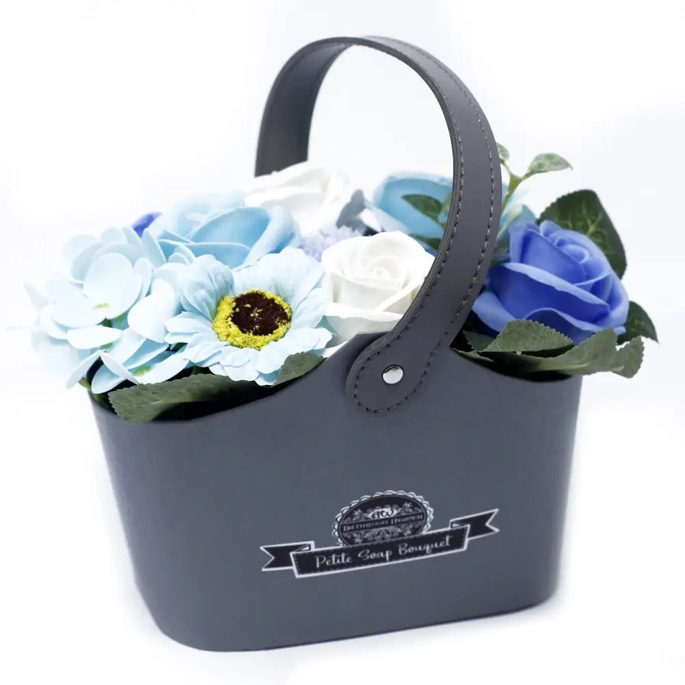 Tvåltulpanbukett med blå och vita blommor i en mörkgrå korg med handtag