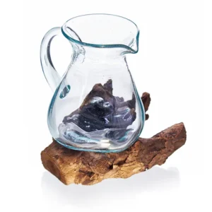 Vattenkanna i handblåst glas placerad på en träfot av naturligt trä