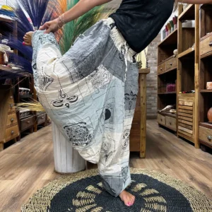 Person som bär grå yoga- och festivalbyxor med Aladdin-inspirerat mönster i en butiksmiljö