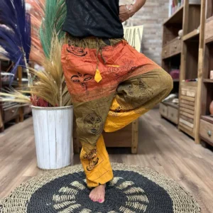 Person som bär färgglada yoga- och festivalbyxor med Himalaya-inspirerat mönster i en butiksmiljö
