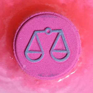 Rosa badbomb med Vågens stjärntecken symbol i badvatten