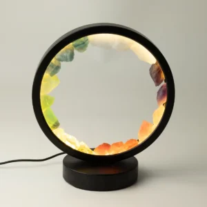 Rund lampa med svart ram och sju färgade naturliga ädelstenar i cirkel