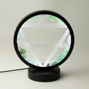 Rund lampa med svart ram och bas, dekorerad med gröna aventurinstenar och vita selenitstavar