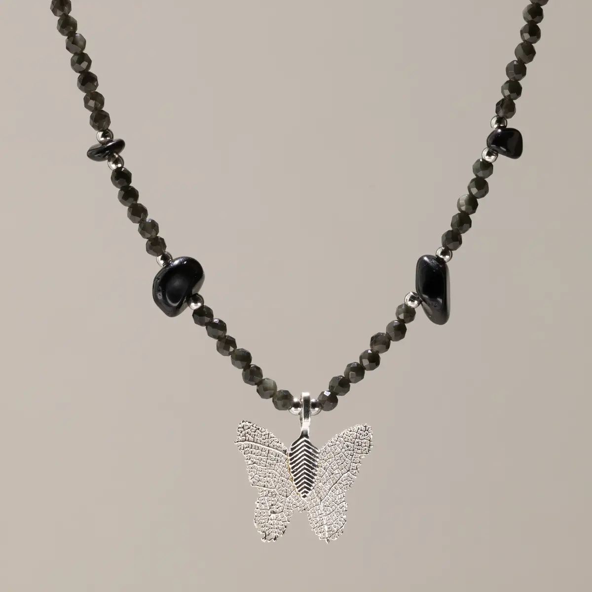 Nymph halsband med svarta obsidianpärlor och silverpläterad fjärilsberlock i äkta blad