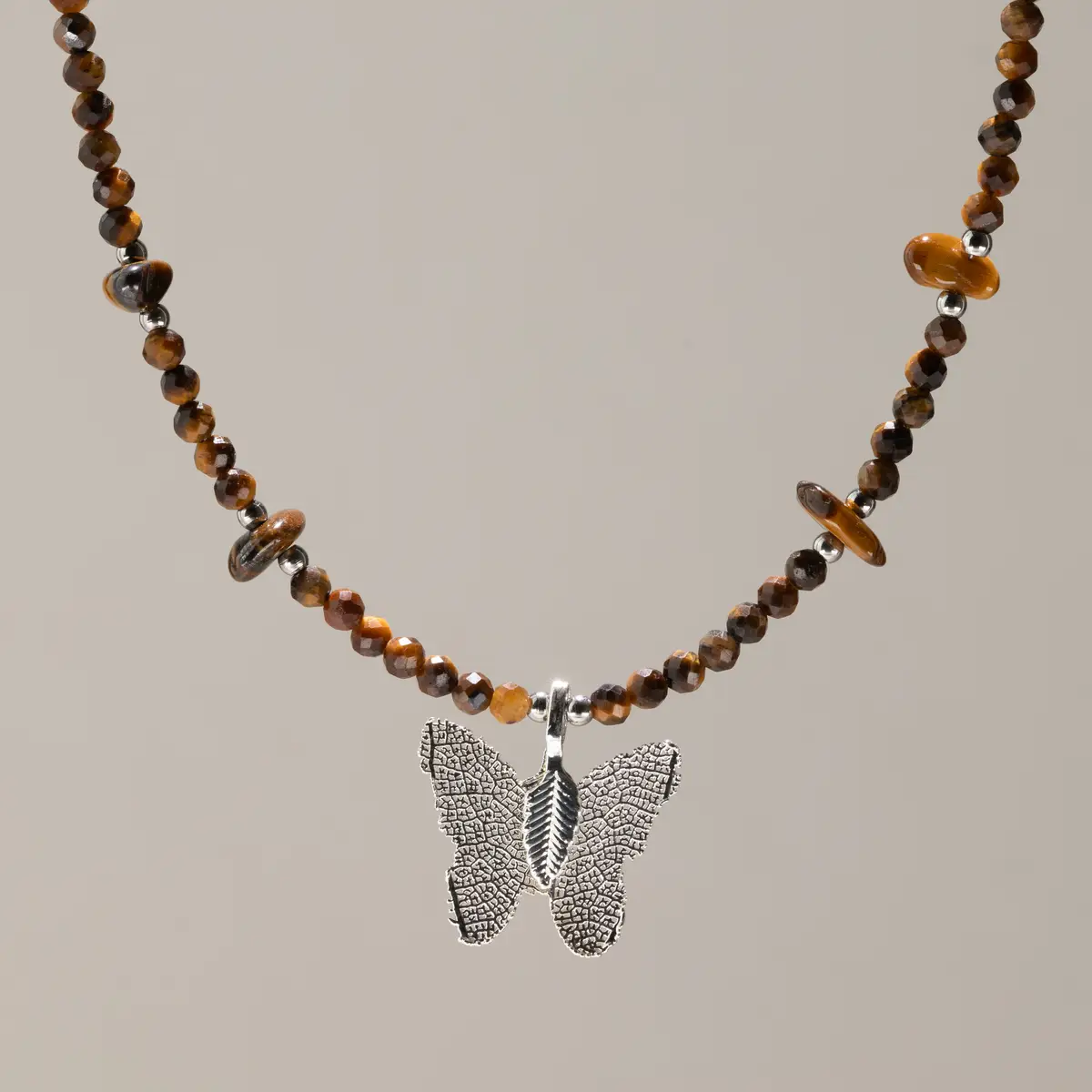 Nymph halsband med fasettslipade tigeröga-pärlor och silverpläterad fjärilsberlock i äkta blad